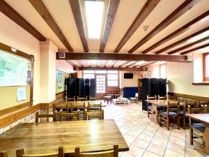 a classroom with wooden tables and chairs in a room at Albergue Urbasa in Eulate
