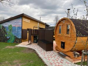 a large wooden house next to a building with a mural at Rojas Rodes in Roja