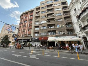 a city street with a tall building in the background at Victoriei Avenue Gem in Bucharest
