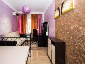 sala de estar con paredes de color púrpura y sofá en ApartLux Kremlyovskaya, en Moscú