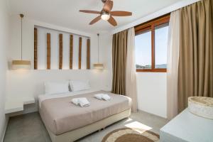 a bedroom with a bed and a ceiling fan at Villa Eva Milos near the beach and Adamas in Adamantas +32 photos