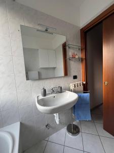 Un baño con un lavabo blanco y un espejo. en Appartamento Camineve 2, en Loano 2 fotos más