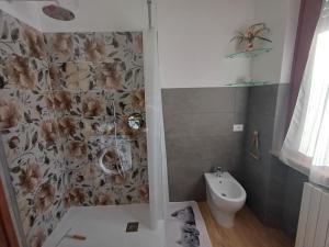 a bathroom with a toilet and a flower patterned wall at Dalla Nonna Ida, Casa Vacanze con Vista in Toscana in Sestino
