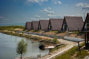 a row of houses on the side of a river at Lagos Lac de Pescuit in Boiştea-Boerească