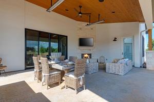 een eetkamer met een tafel en stoelen en een open haard bij Calivence Haus - Estate Home in Fredericksburg