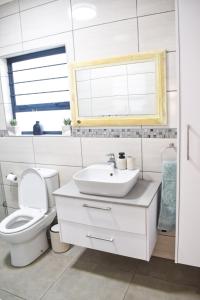 a white bathroom with a toilet and a sink at Desert Nest II in Swakopmund +41 photos