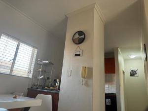 a kitchen with a clock on a wall next to a refrigerator at Midrand Apartment near Mall of Africa in Midrand +29 photos