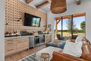 een woonkamer met een bank en een tv bij Calivence Haus - Estate Home in Fredericksburg