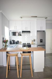 a kitchen with white cabinets and a wooden counter top at Desert Nest II in Swakopmund