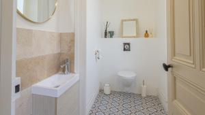 a bathroom with a sink and a toilet and a mirror at La Suite du Manoir - Champagne et Sérénité in Chappes +21 photos