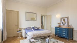 a bedroom with a bed and a blue dresser at La Suite du Manoir - Champagne et Sérénité in Chappes