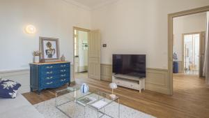 a living room with a television and a blue dresser at La Suite du Manoir - Champagne et Sérénité in Chappes