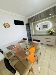 a dining room with a glass table and chairs at Casa espaçosa - 3 quartos - Caçari in Boa Vista