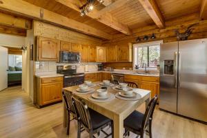 a kitchen with a table with chairs and a refrigerator at Covered Deck, Private Acreage: Log Cabin in Pine in Pine