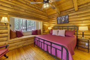 a bedroom in a log cabin with a bed and a window at Covered Deck, Private Acreage: Log Cabin in Pine in Pine