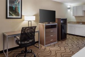 a hotel room with a desk with a television and a chair at Best Western Heritage Inn in Concord