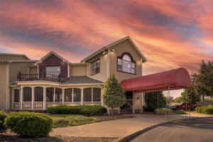 a house with a red awning in front of it at SureStay Plus Hotel by Best Western Auburn in Auburn