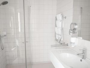 a bathroom with a shower and a sink and a mirror at Hotell Sydjemten in Svenstavik