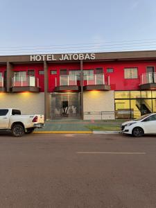 a hotel with two cars parked in front of it at Hotel Jatobás Sinop in Sinop