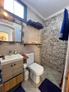 a bathroom with a toilet and a sink and a mirror at Nour roof top apartment in Essaouira