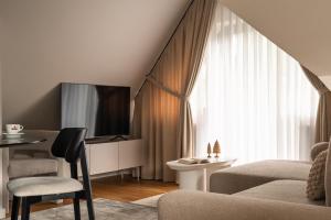 a living room with a couch and a tv at Altara Apartamenty Centrum - Free Parking in Zakopane