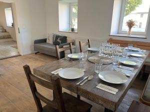 a wooden table with plates and wine glasses on it at Binter Haus -Rattendorf in Rattendorf +60 photos