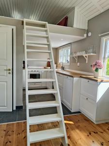 a ladder in a kitchen with white cabinets at Haus Alva in Ronneby