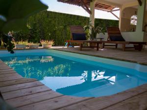 a swimming pool with two chairs and a picnic table at Casa Azul in Trancoso