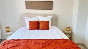 a bedroom with a bed with red and white pillows at Apartment for 6 people - near Brussels & Airport in Wezembeek-Oppem