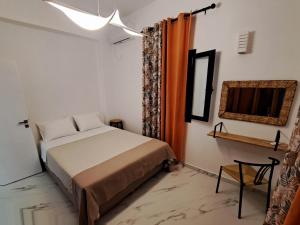 a bedroom with a bed and a mirror and a chair at DaGiorgio in Pitsiniánika