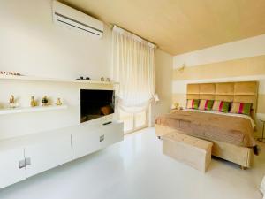 una camera da letto con un letto e una TV di Mora Suite a Bari