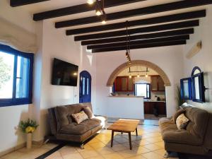 a living room with two couches and a table at DaGiorgio in Pitsiniánika
