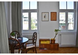 a dining room with a table and chairs and windows at vintage house - LGBTQ & female friendly in Vienna