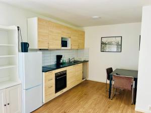 a kitchen with a white refrigerator and a table at Comfortable accommodation in nearby Eslöv station in Eslöv