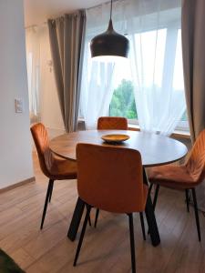 a dining room table with chairs and aendant light at 'Design korter Kehras' in Kekra