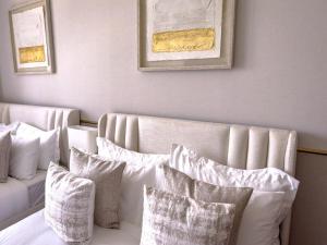 a white couch with pillows in a room at GRANDE RESIDENCES with a direct Burj Khalifa view and Private Fountain Show at 31st floor with DXB AIRPORT VIP Shuttle in Dubai