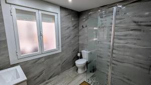a bathroom with a toilet and a glass shower at Casa Clari in Motilla del Palancar +19 photos