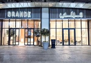 a grand entrance to a store with large glass doors at GRANDE RESIDENCES with a direct Burj Khalifa view and Private Fountain Show at 31st floor with DXB AIRPORT VIP Shuttle in Dubai