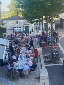 a large crowd of people sitting at long tables at Les Papillons in Verteillac