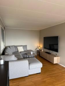 a living room with a couch and a flat screen tv at Hermelinveien 6 in Tønsberg