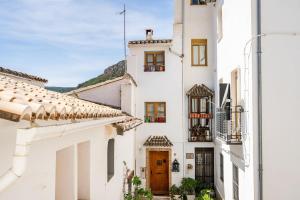 un edificio bianco con porta marrone e finestre di Casa la Baronia a Chulilla