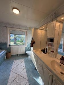 a bathroom with two sinks and a tub and a toilet at Hermelinveien 6 in Tønsberg