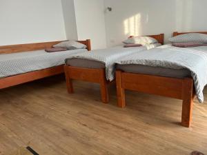 two twin beds in a room with wooden floors at Casa Miron in Dezmir