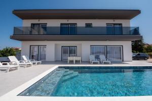 a house with a swimming pool in front of a house at Villa Vibiana Lux Bibinje in Bibinje