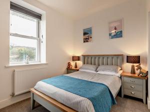 un dormitorio con una cama y una ventana en 2 Bed in Woolacombe 90798, en Mortehoe
