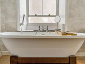 a white bath tub in a bathroom with a mirror at 1 Bed in Cockermouth 93147 in Cockermouth
