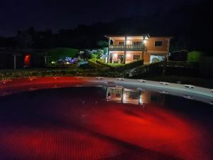 una casa con piscina por la noche en Oasis Inn Pedornes, en Pedornes