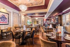 a restaurant with tables and chairs and a bar at Royal Station Hotel- Part of the Cairn Collection in Newcastle upon Tyne