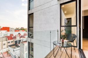 een glazen tafel op een balkon met uitzicht op de stad bij MEDELLIN by Mr W in Mexico-Stad