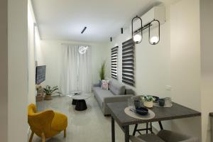 a living room with a table and a couch at OMEGA - Deluxe Central Apartment by Optimum Link in Katerini